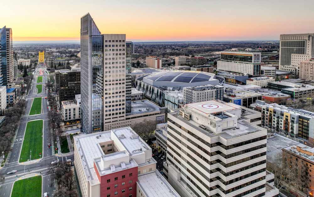 Aerial view of a downtown with a tall tower at sunset
