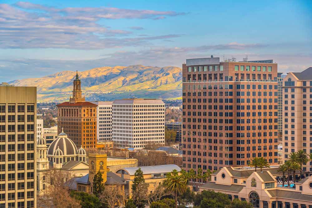 Downtown buildings with a domed tower and hills beyond