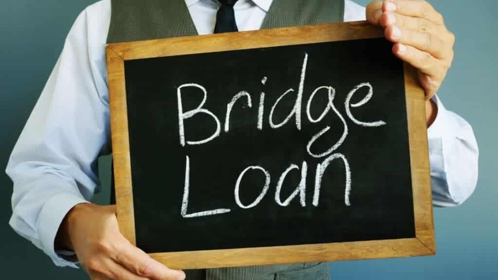 Person holding a chalkboard reading Bridge Loan