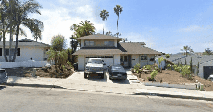 Hillside homes with palm trees and parked cars