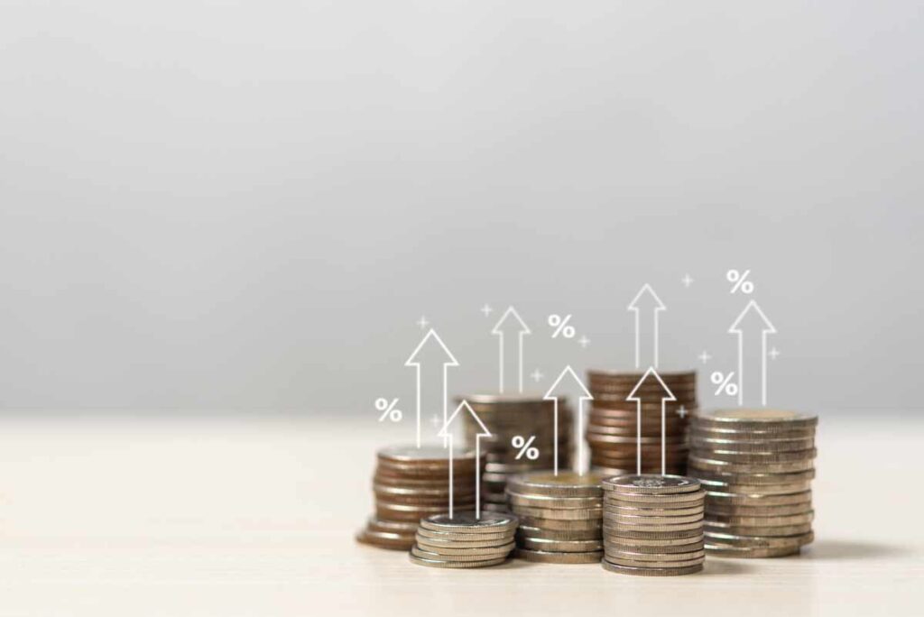 Stacks of coins with rising arrows and percent signs