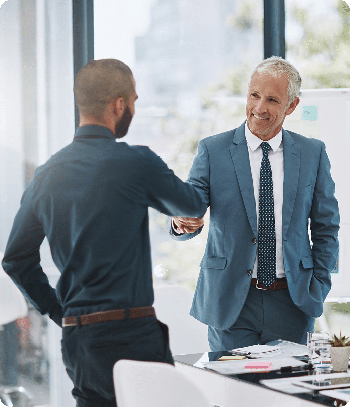 Two businessmen shaking hands in a bright office