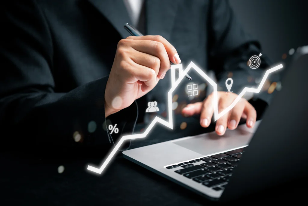 Hands on a laptop with a rising chart graphic overlaid