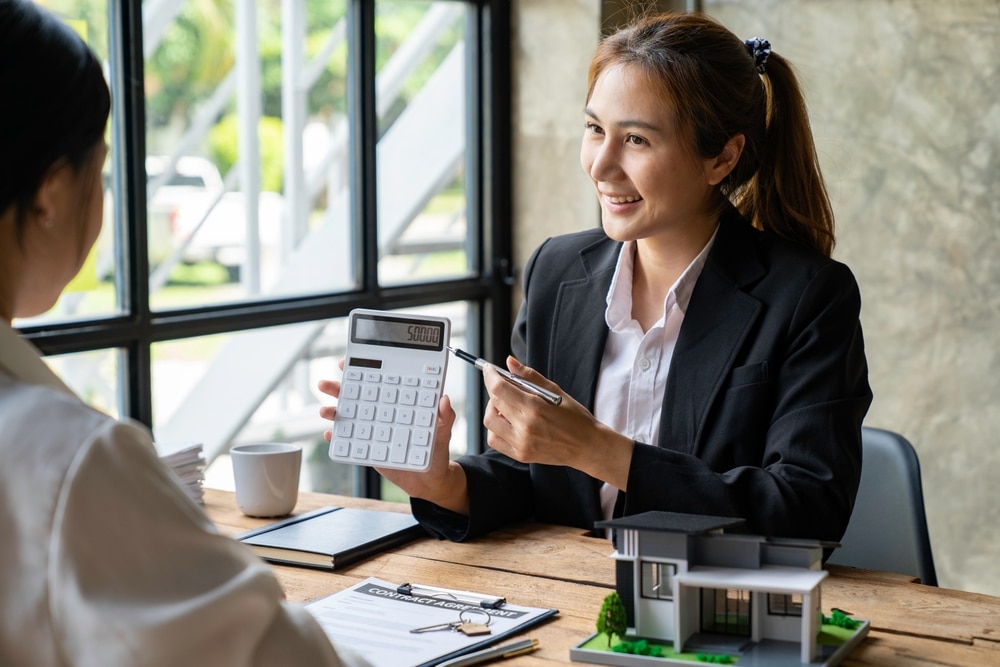 Woman holding a calculator while talking with a client