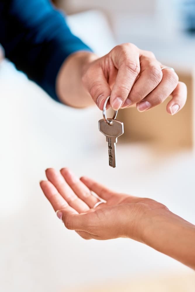 Hand dropping a key into an open palm